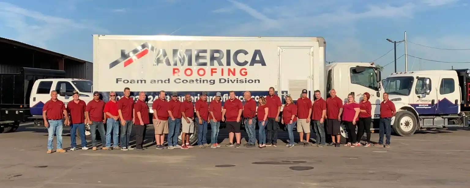 America Roofing team standing in front of branded company trucks