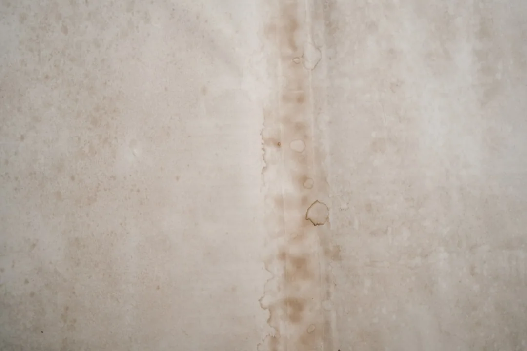Water stains on a ceiling near a corner, indicating a roof leak. - phoenix townhouse roof repair