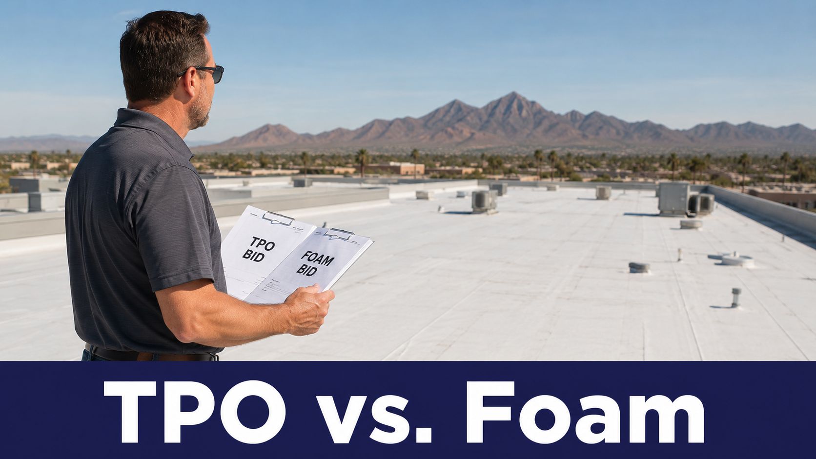 A professional roofing contractor holds bid documents on a commercial rooftop with a view of mountains.