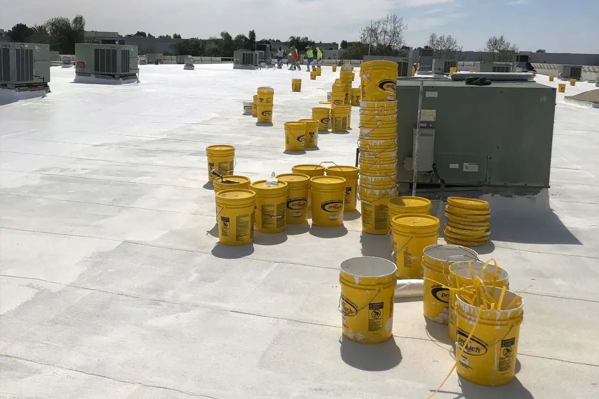 Contractor applying a Pro-Tech protective coating to a low-slope roof