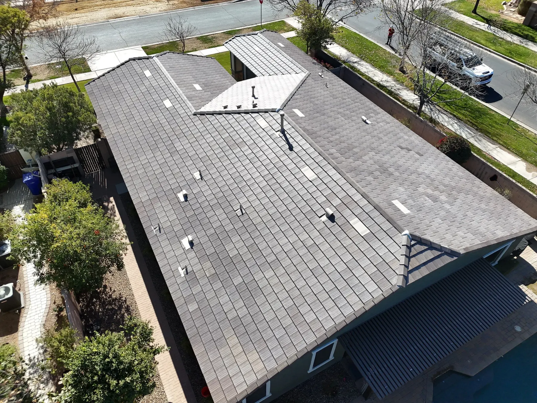 Large finished gray tile roof with multiple penetrations