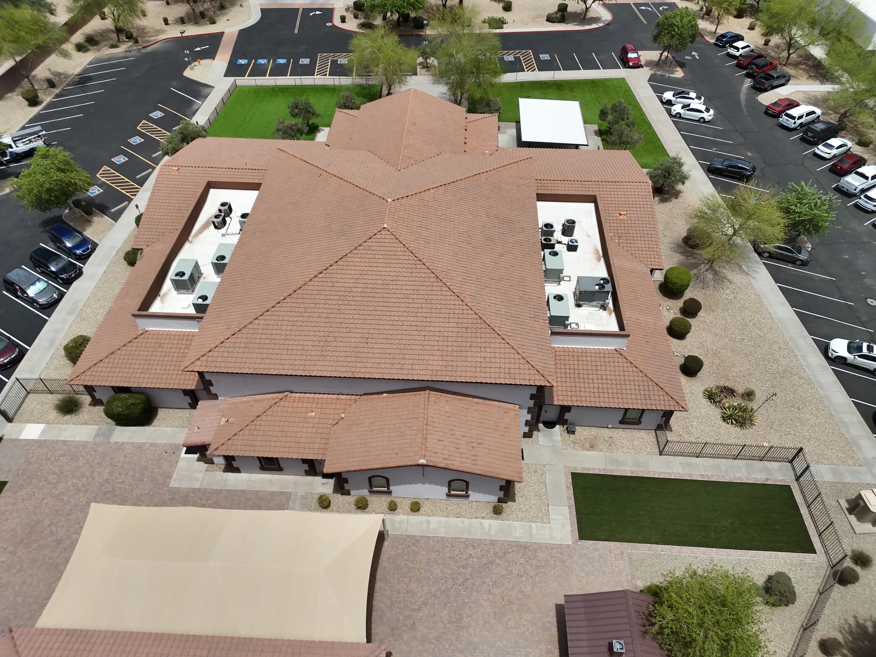 High aerial view of completed tan tile roof enclosing twin white mechanical wells