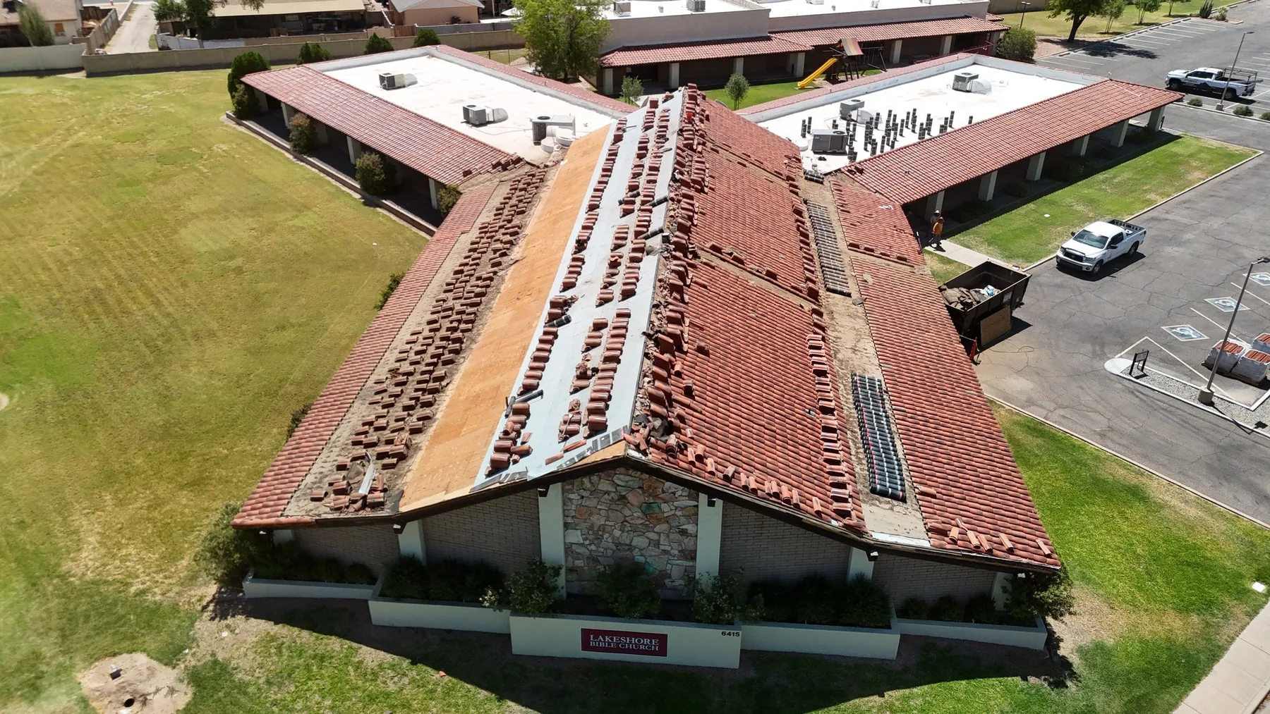 End-on aerial view of red tile roof with broad exposed decking and underlayment strips