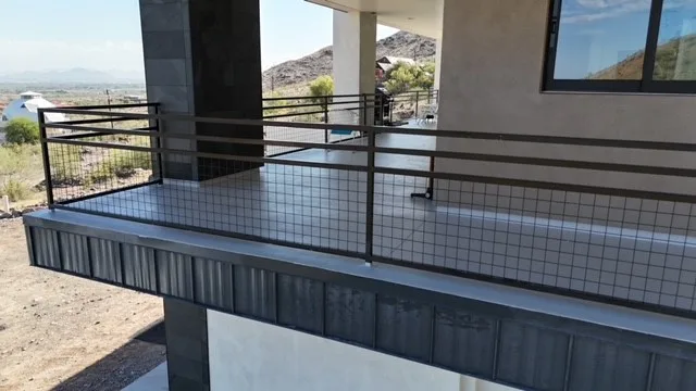 Oblique view of gray waterproof balcony deck with black railings and dark fascia