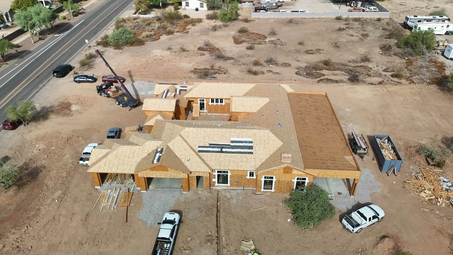 High aerial view of tan roof sheathing with unfinished walls and rectangular roof openings
