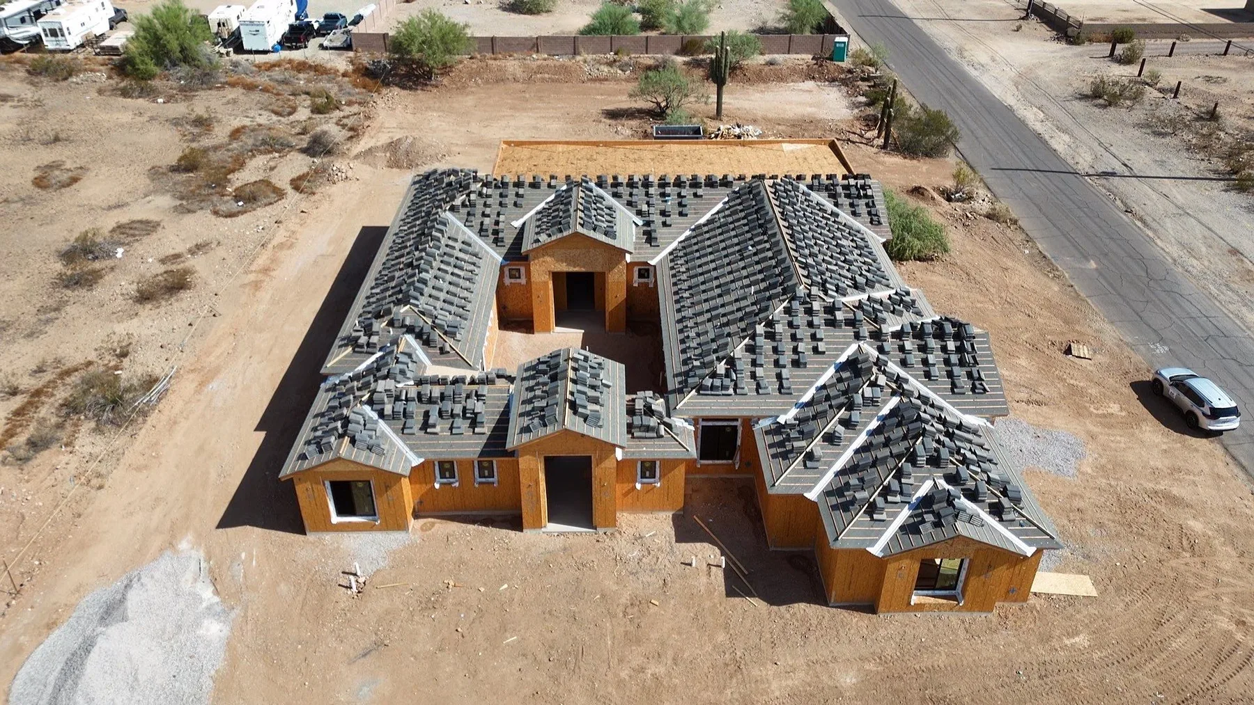 High aerial view of gray underlayment and battens across multiple gables above orange walls