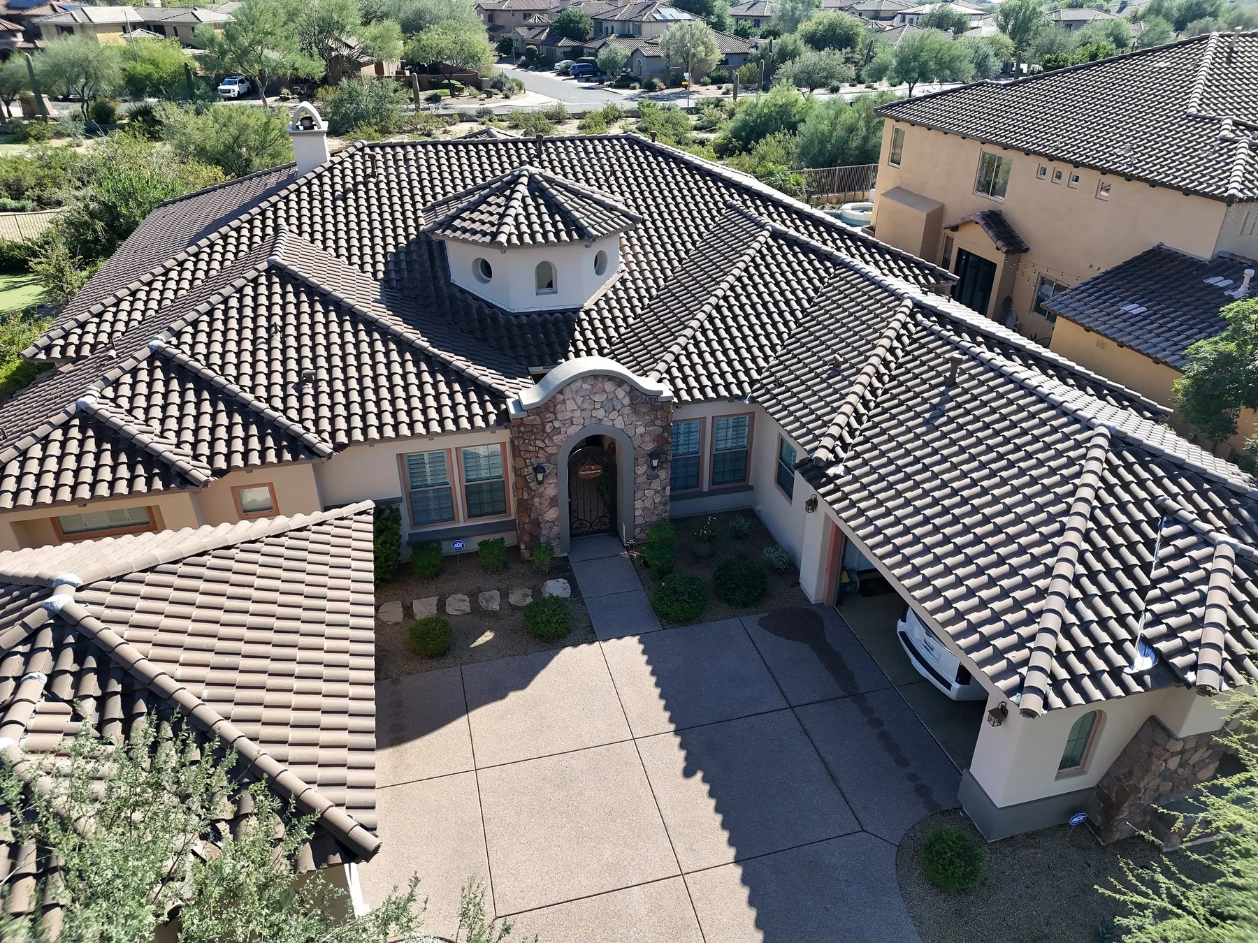 Oblique aerial view of completed gray barrel tile roof with central turret and courtyard