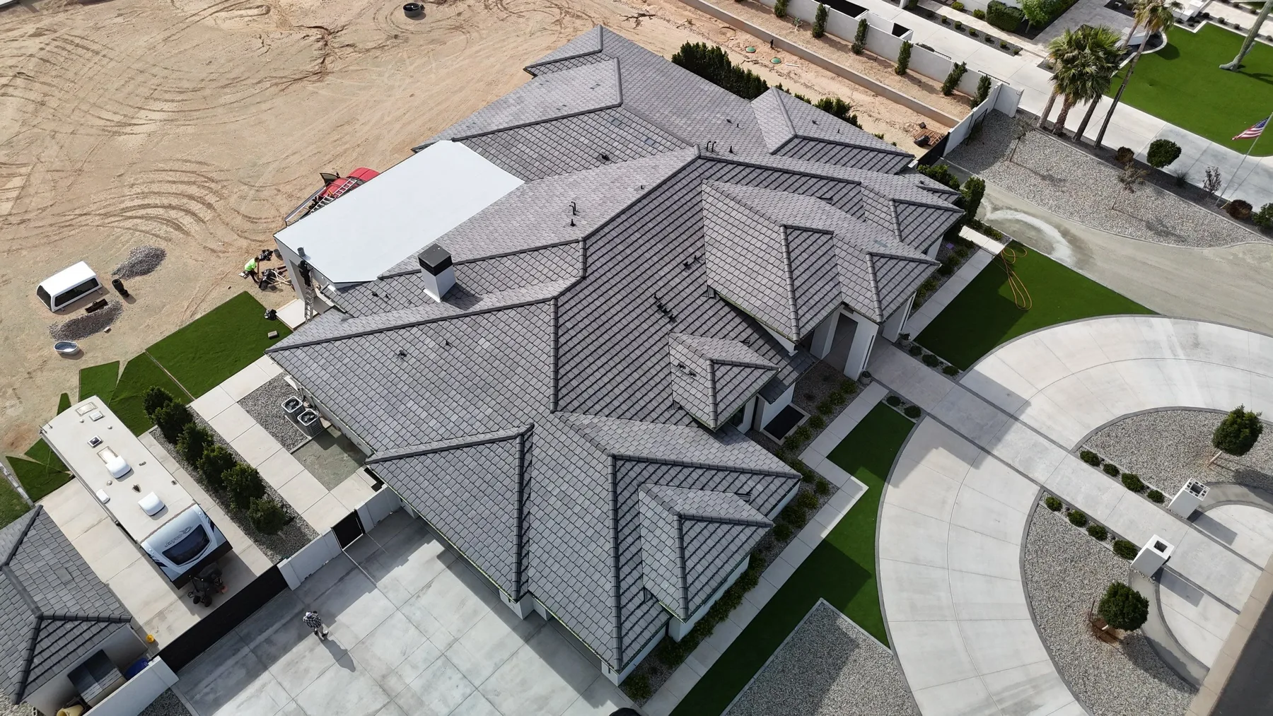 Oblique aerial view of completed gray tile roof with numerous intersecting hips