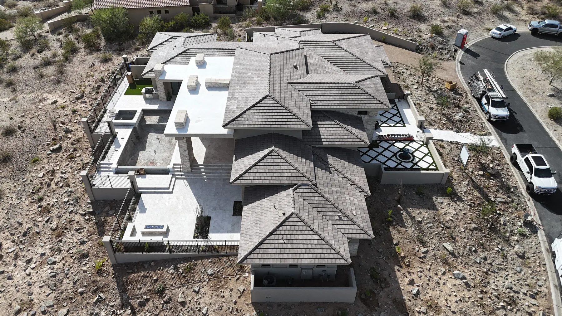 Top-down aerial view of gray tiled hips and white low-slope sections around courtyards