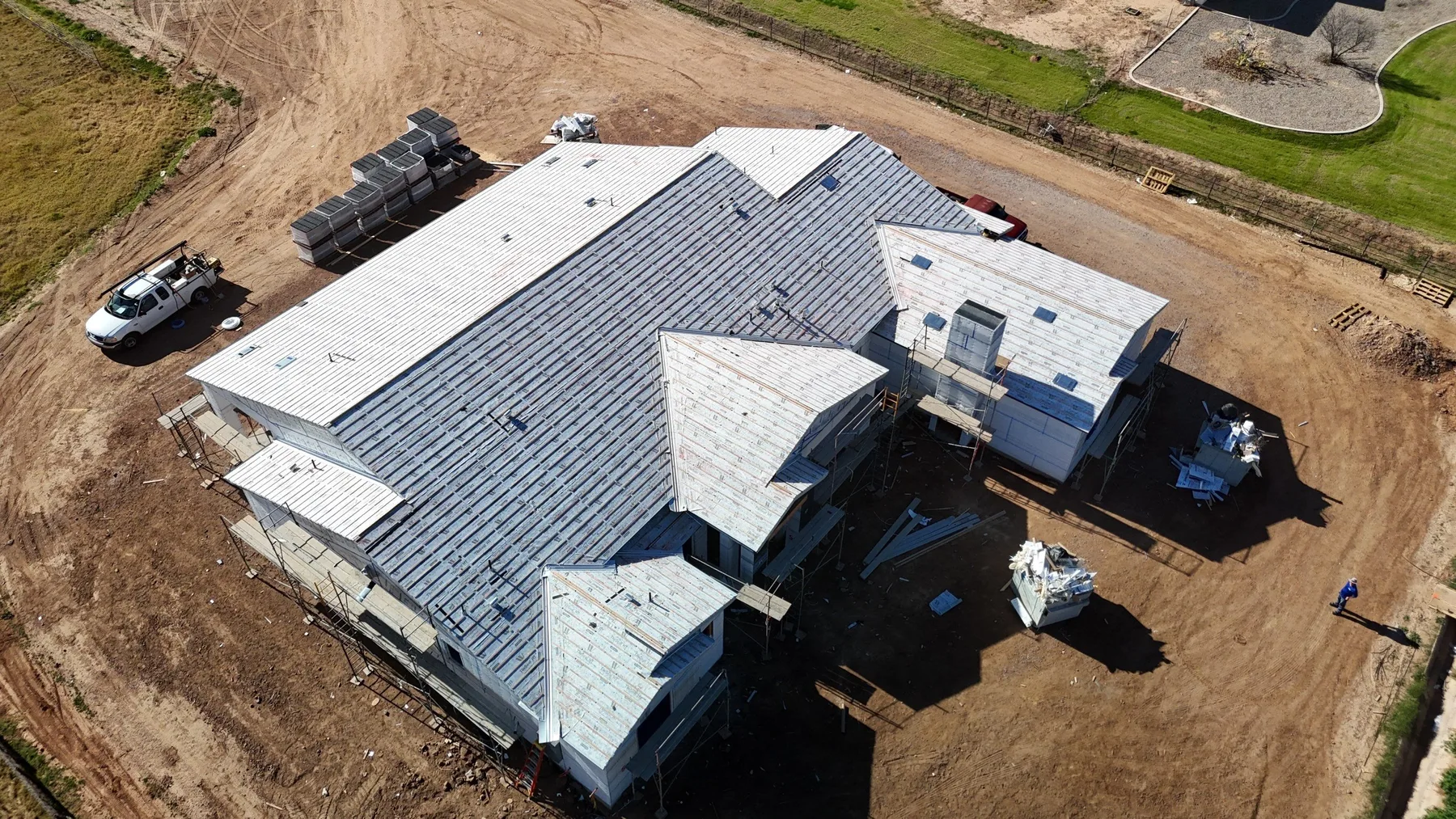 Aerial view of gray underlayment covering a large complex roof with multiple gables