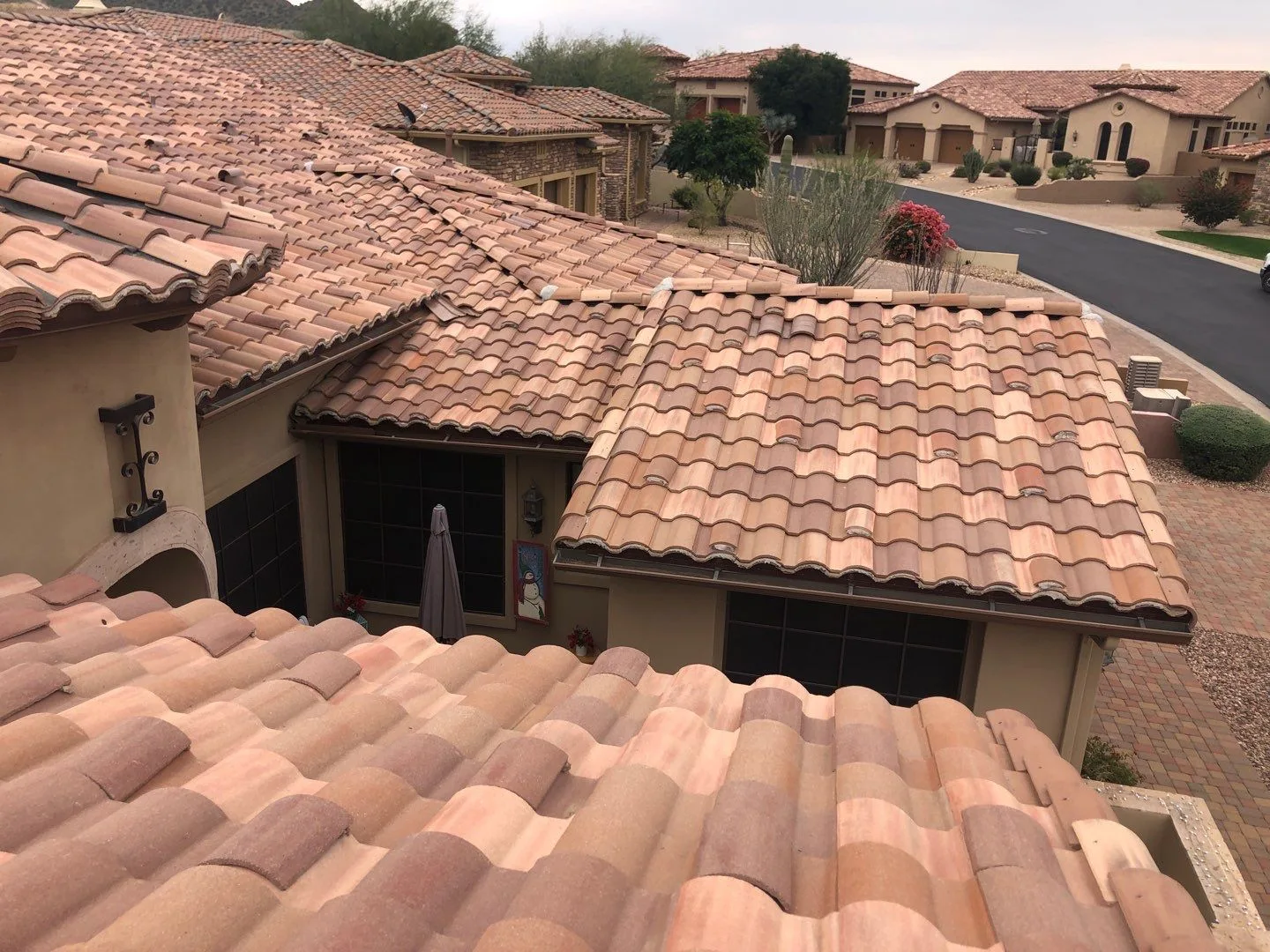 Elevated view of completed terracotta curved tile roofs surrounding a recessed courtyard near homes