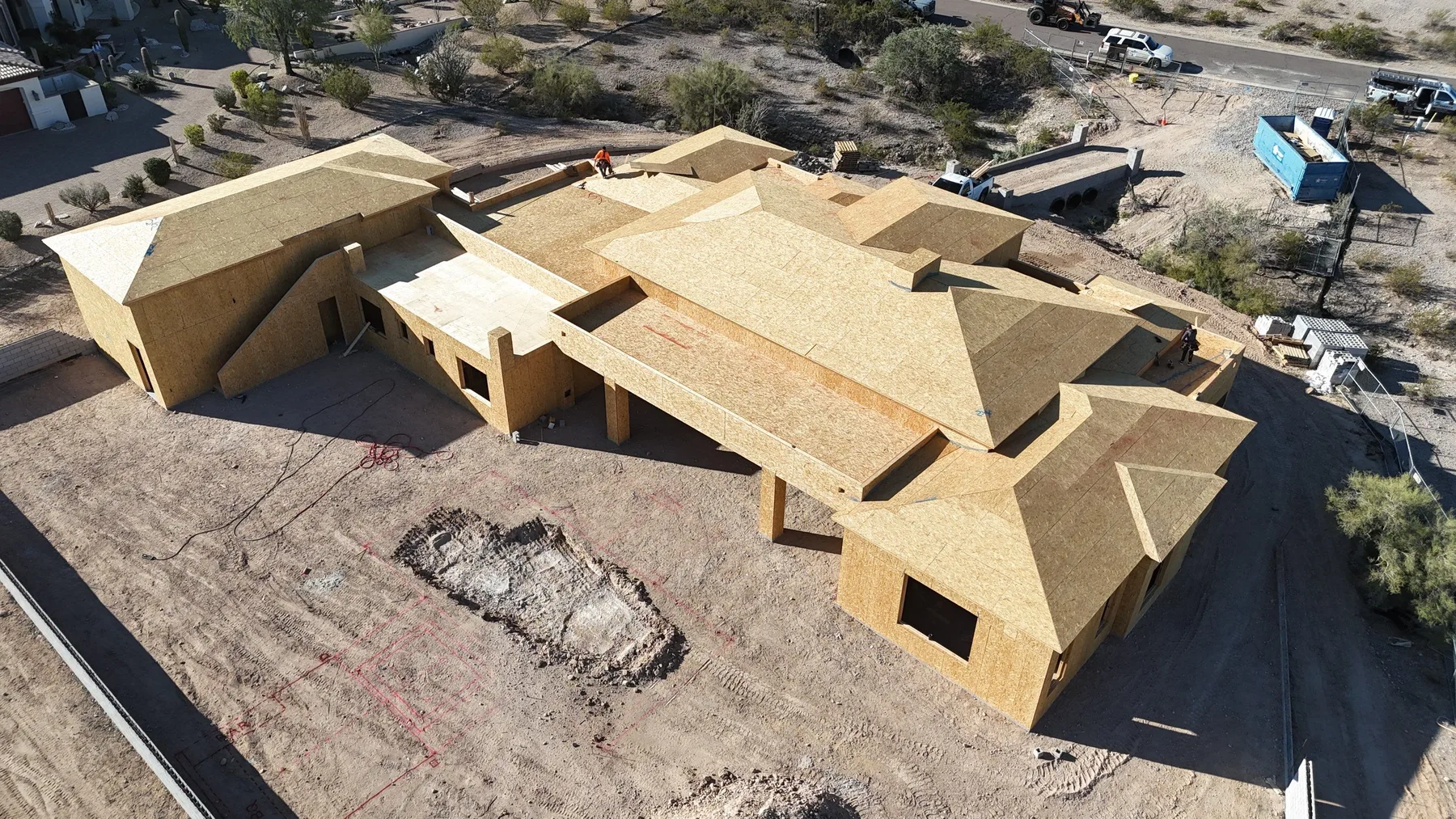 Oblique aerial view of tan wood roof decking on a sprawling framed house