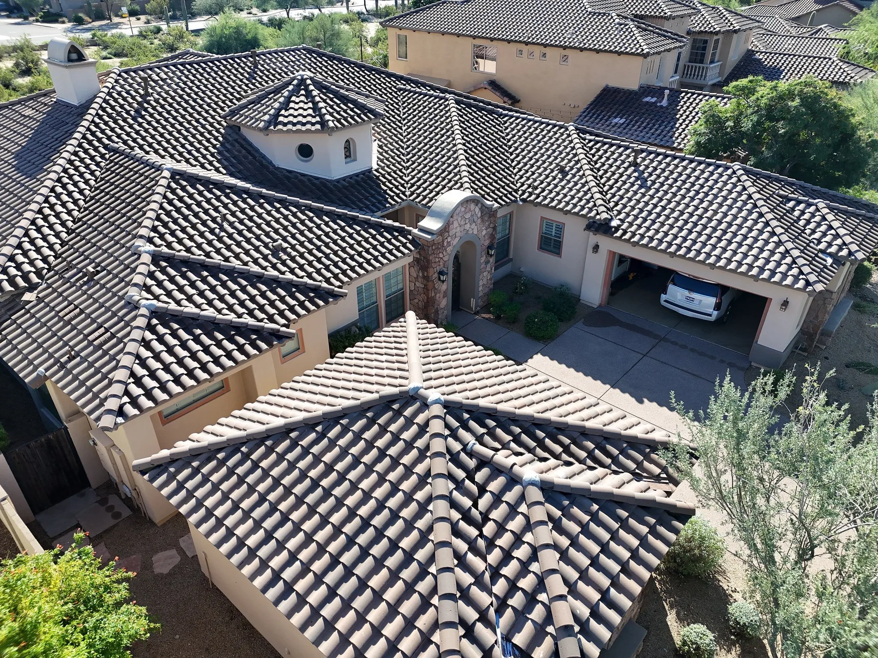 Oblique aerial view of completed tan tiled roof with octagonal turret and arched entry
