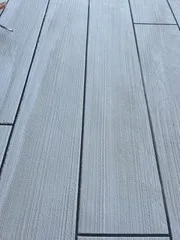 Close-up of blue-gray plank-pattern deck coating with narrow seams and textured grain