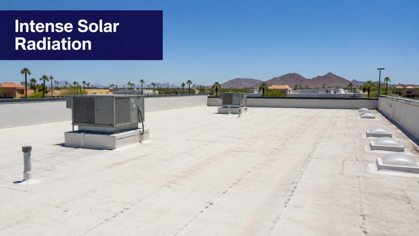 A wide angle view of a flat commercial roof under a clear blue sky in Arizona.